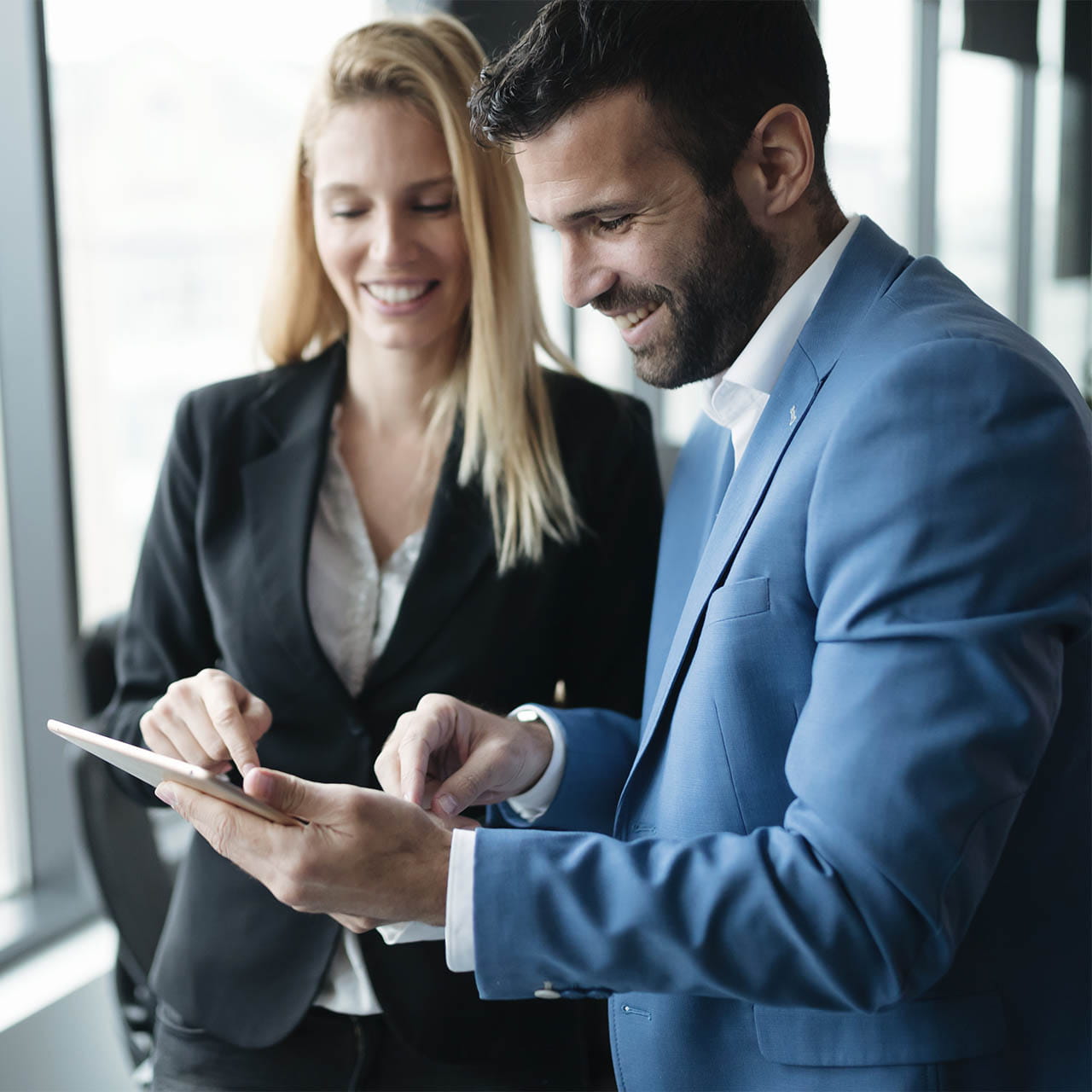 Nainen ja mies katsovat tabletin näyttöä.